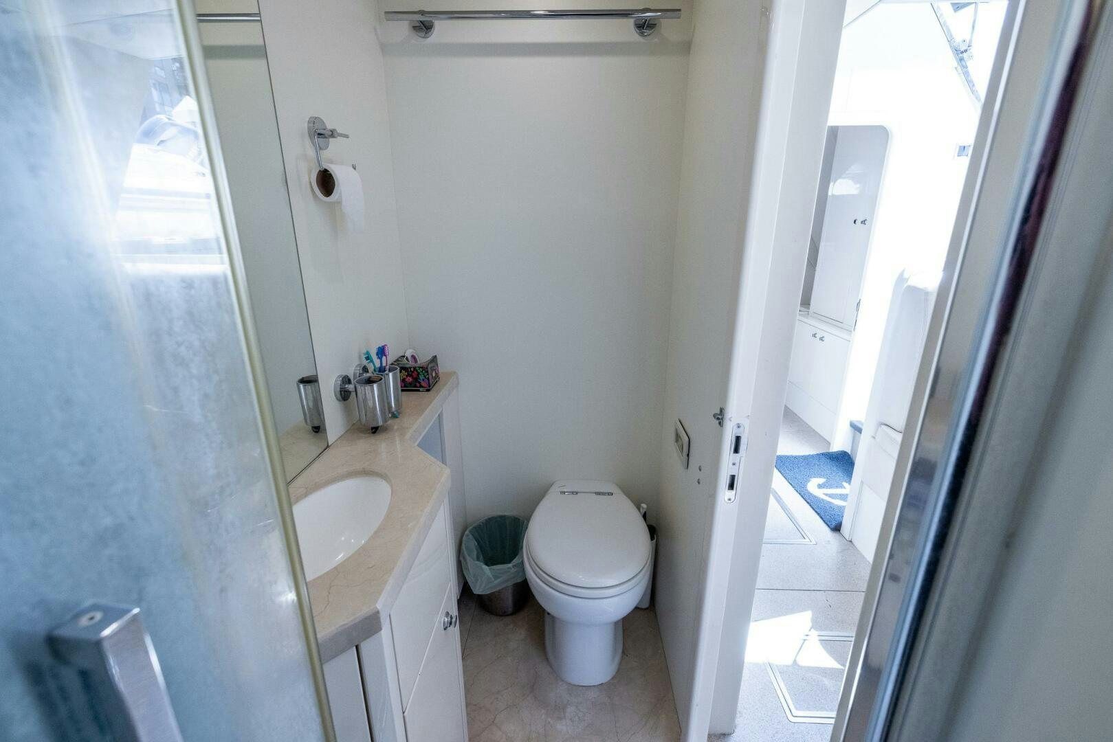 a bathroom with a toilet and sink aboard INDECENT PROPOSAL IV Yacht for Sale