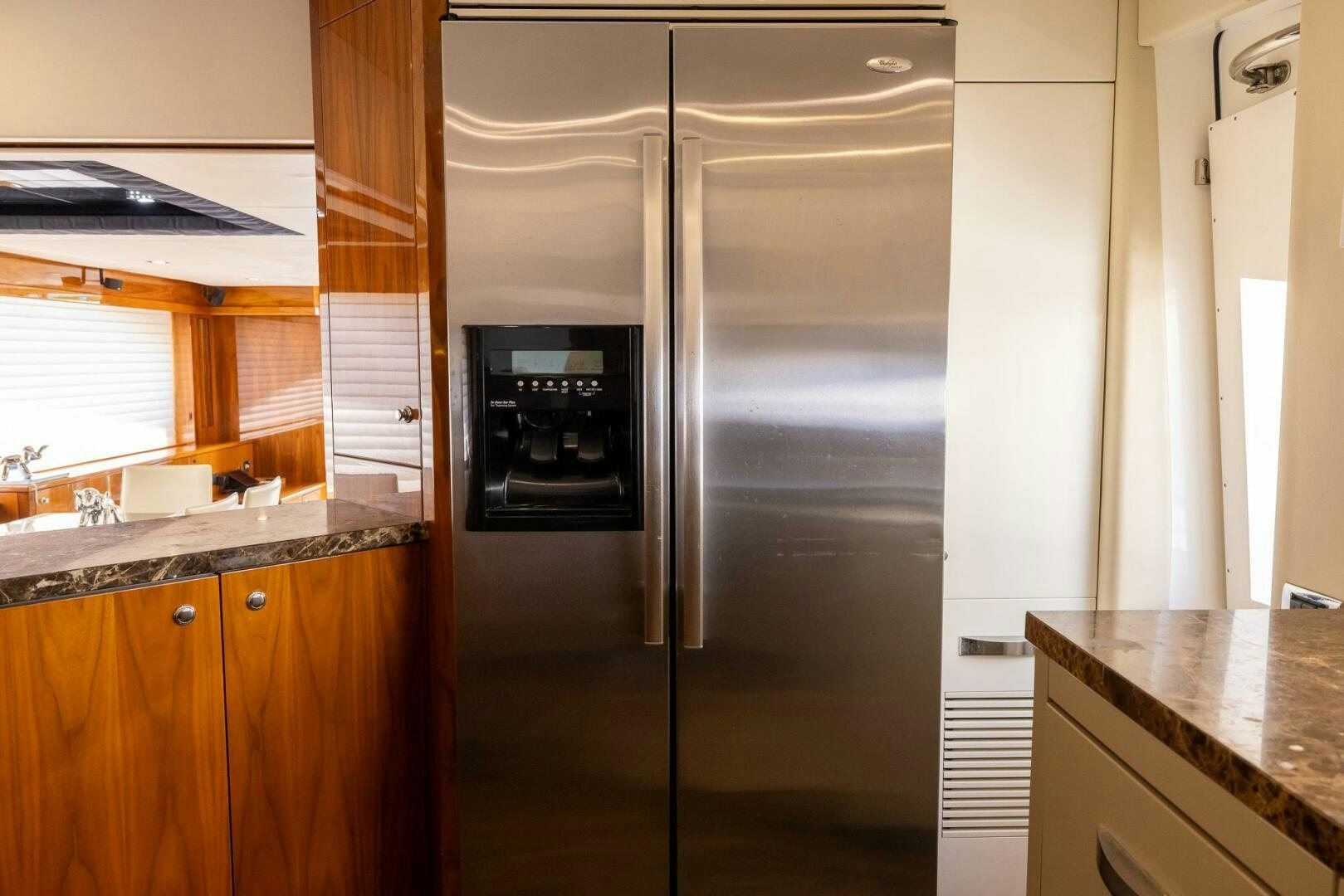 a kitchen with a stainless steel refrigerator aboard INDECENT PROPOSAL IV Yacht for Sale