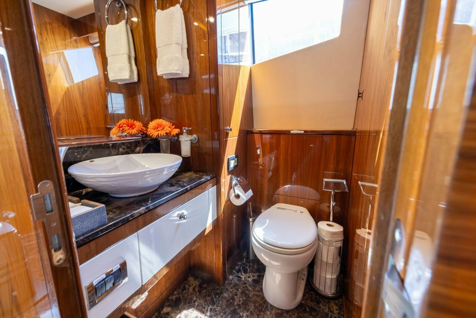 a bathroom with a sink toilet and a mirror aboard INDECENT PROPOSAL IV Yacht for Sale