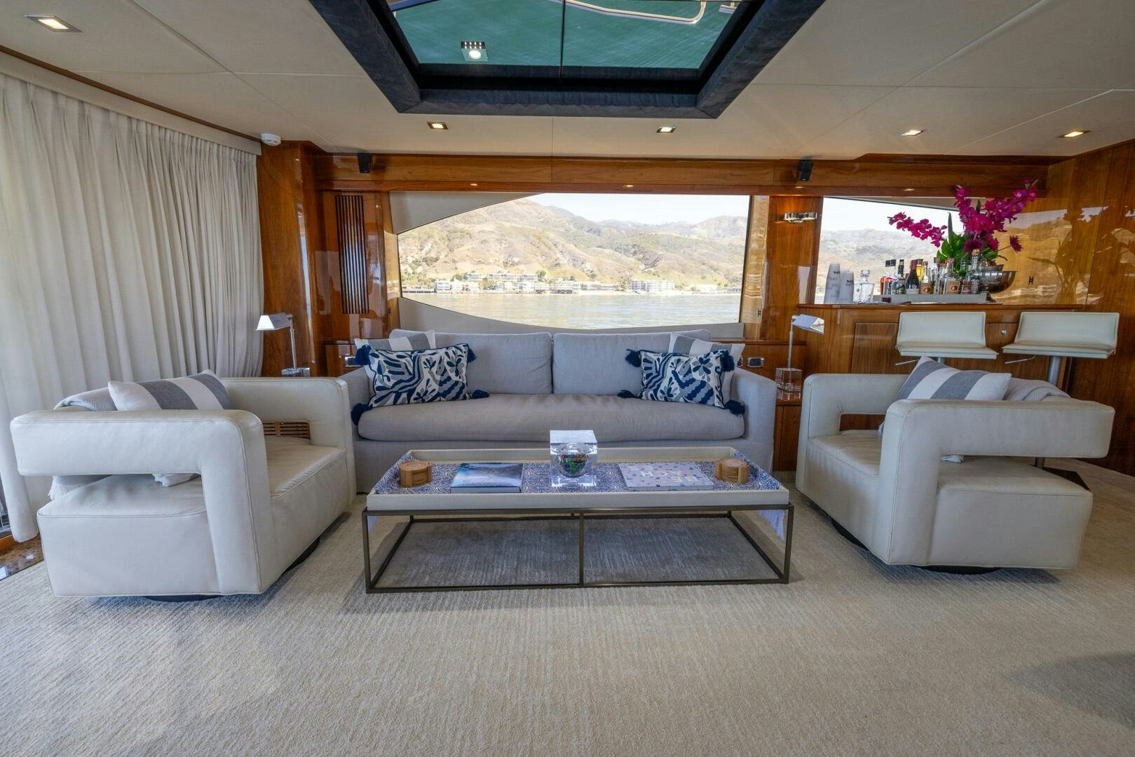 a living room with a large window aboard INDECENT PROPOSAL IV Yacht for Sale