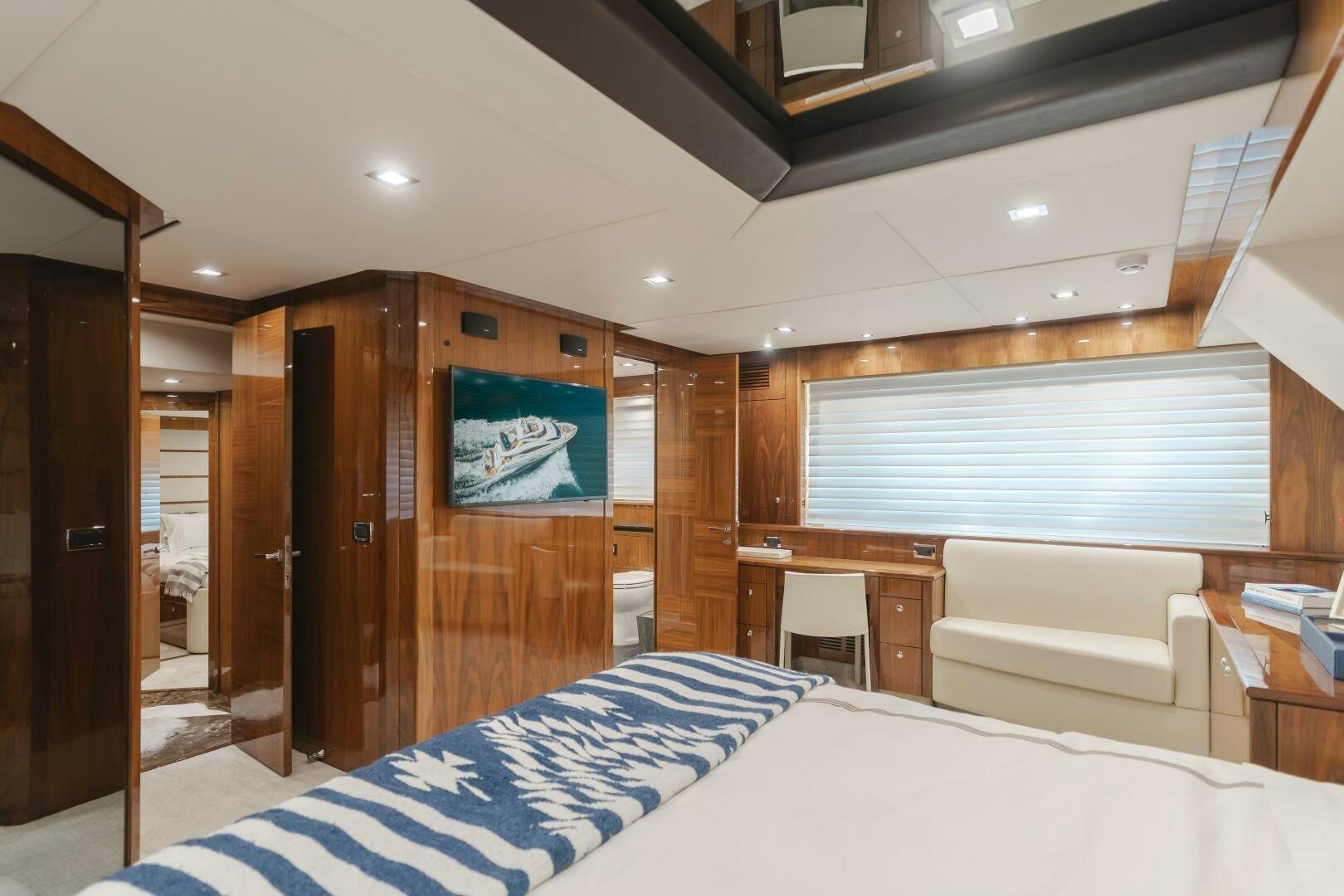 a room with a bed and a desk aboard INDECENT PROPOSAL IV Yacht for Sale