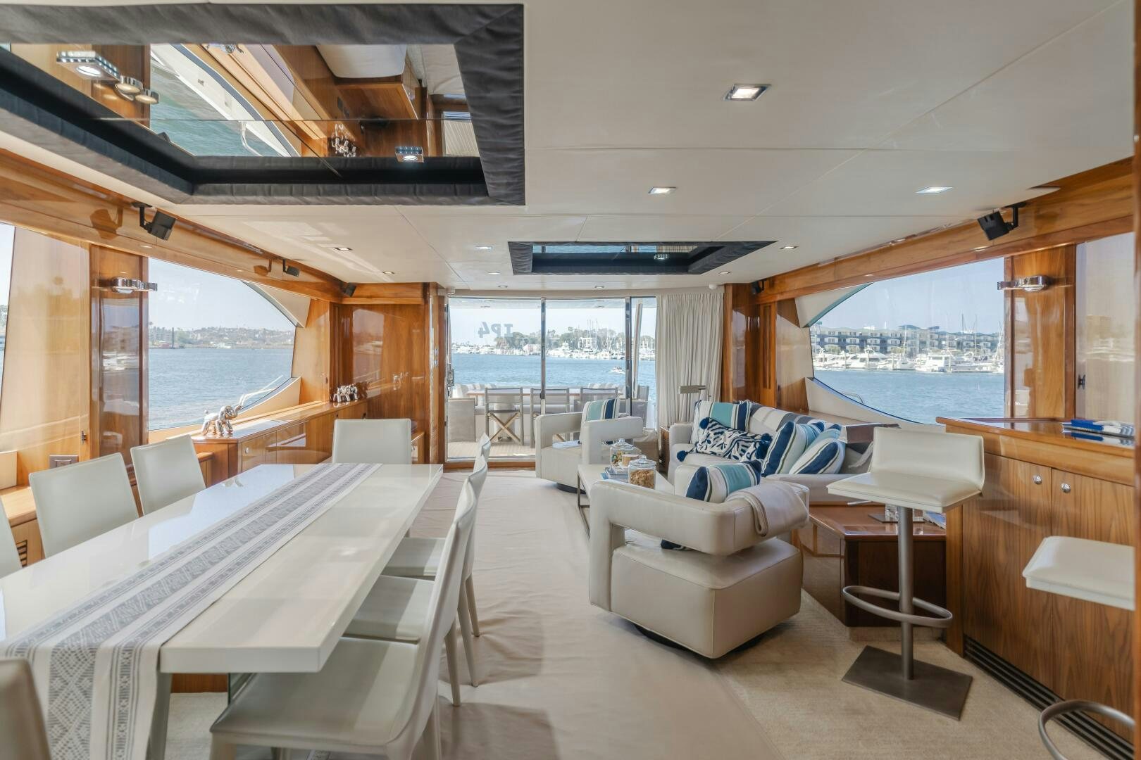 a room with a large window and a table with chairs and a view of the water aboard INDECENT PROPOSAL IV Yacht for Sale