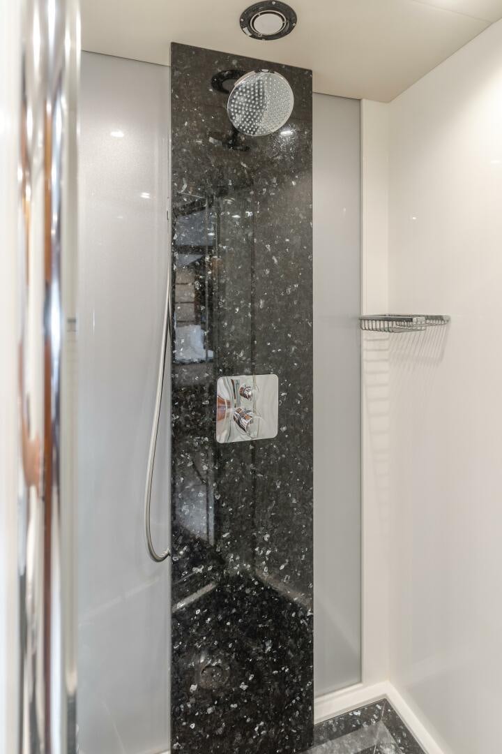 a shower with a black wall aboard INDECENT PROPOSAL IV Yacht for Sale