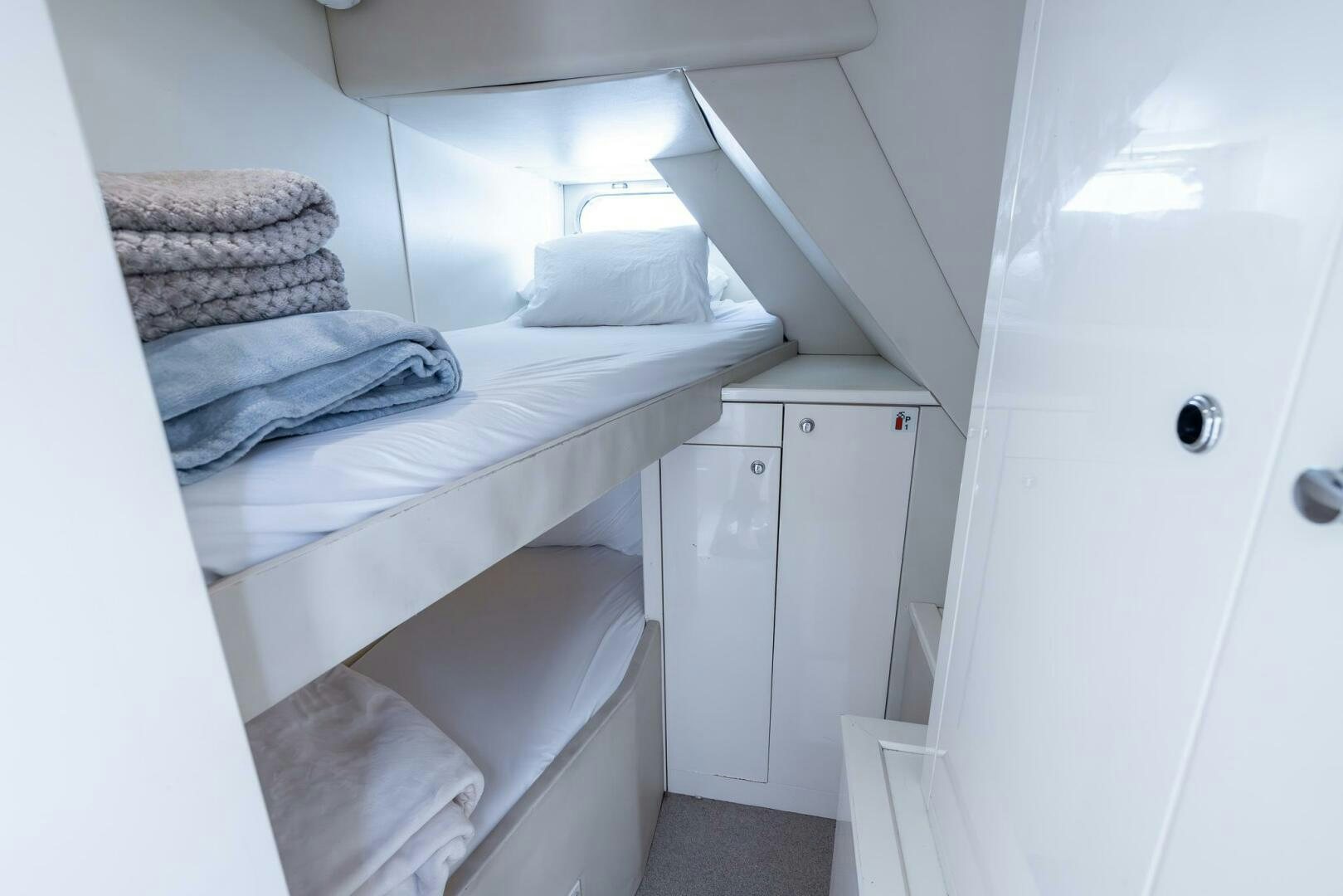 a small white room with two beds aboard INDECENT PROPOSAL IV Yacht for Sale