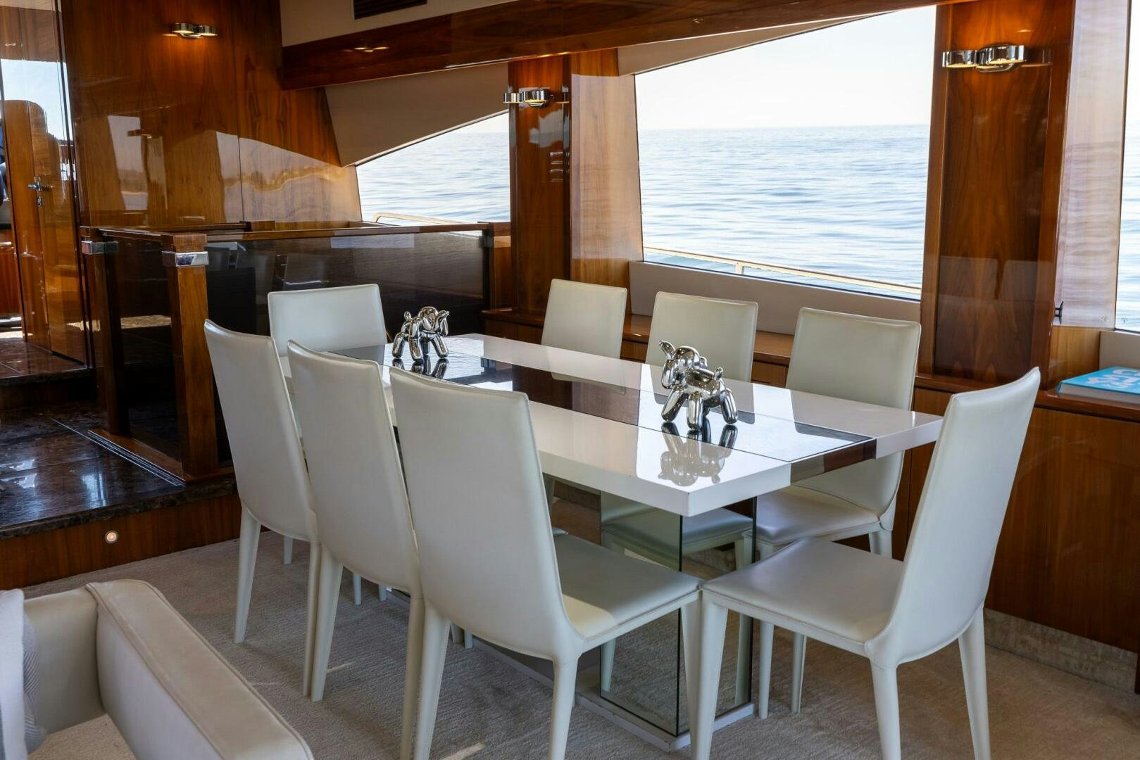 a white table and chairs in a room with a window aboard INDECENT PROPOSAL IV Yacht for Sale