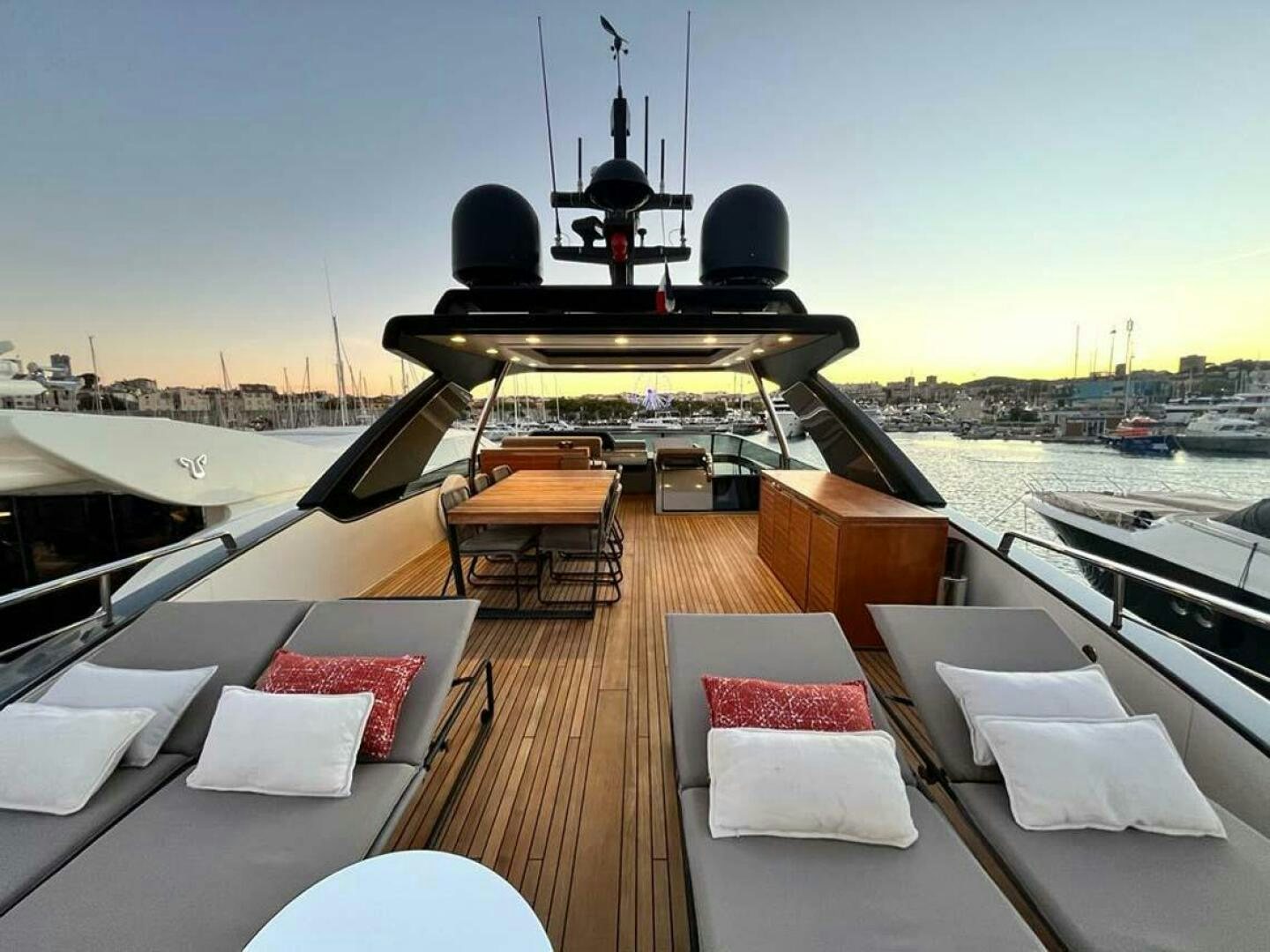 a deck with a table chairs and a large ship in the background aboard SIGNE Yacht for Sale