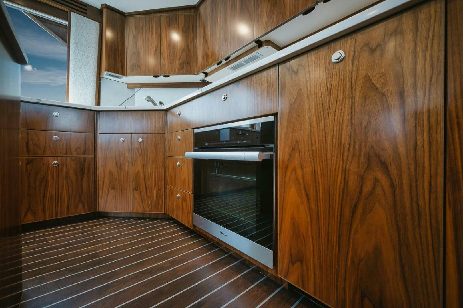 a kitchen with wooden cabinets aboard WHIRLWIND Yacht for Sale