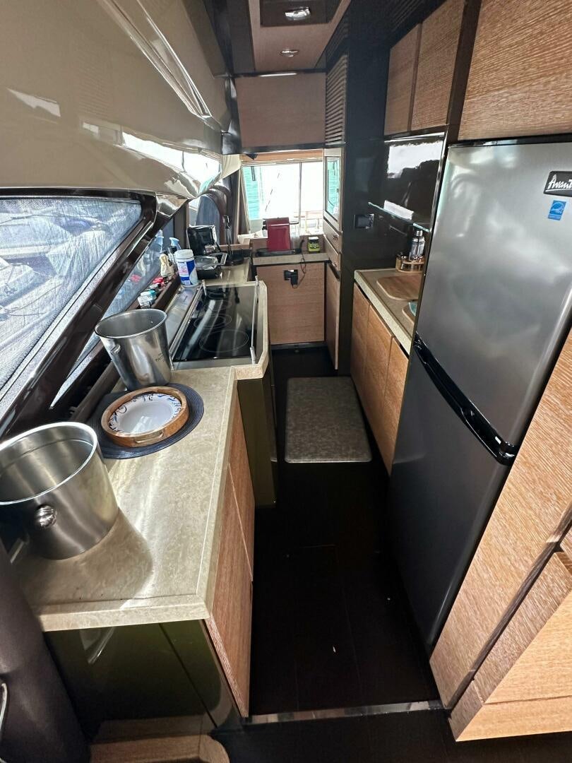 a kitchen with a stainless steel refrigerator aboard SEVEN Yacht for Sale
