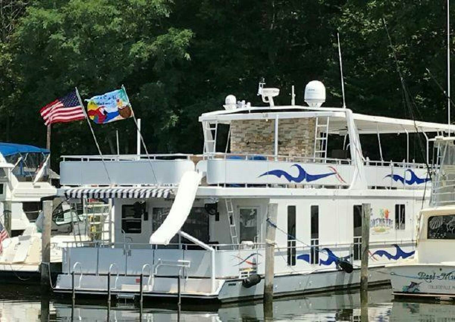 a boat with flags on it aboard ST. SOMEWHERE Yacht for Sale