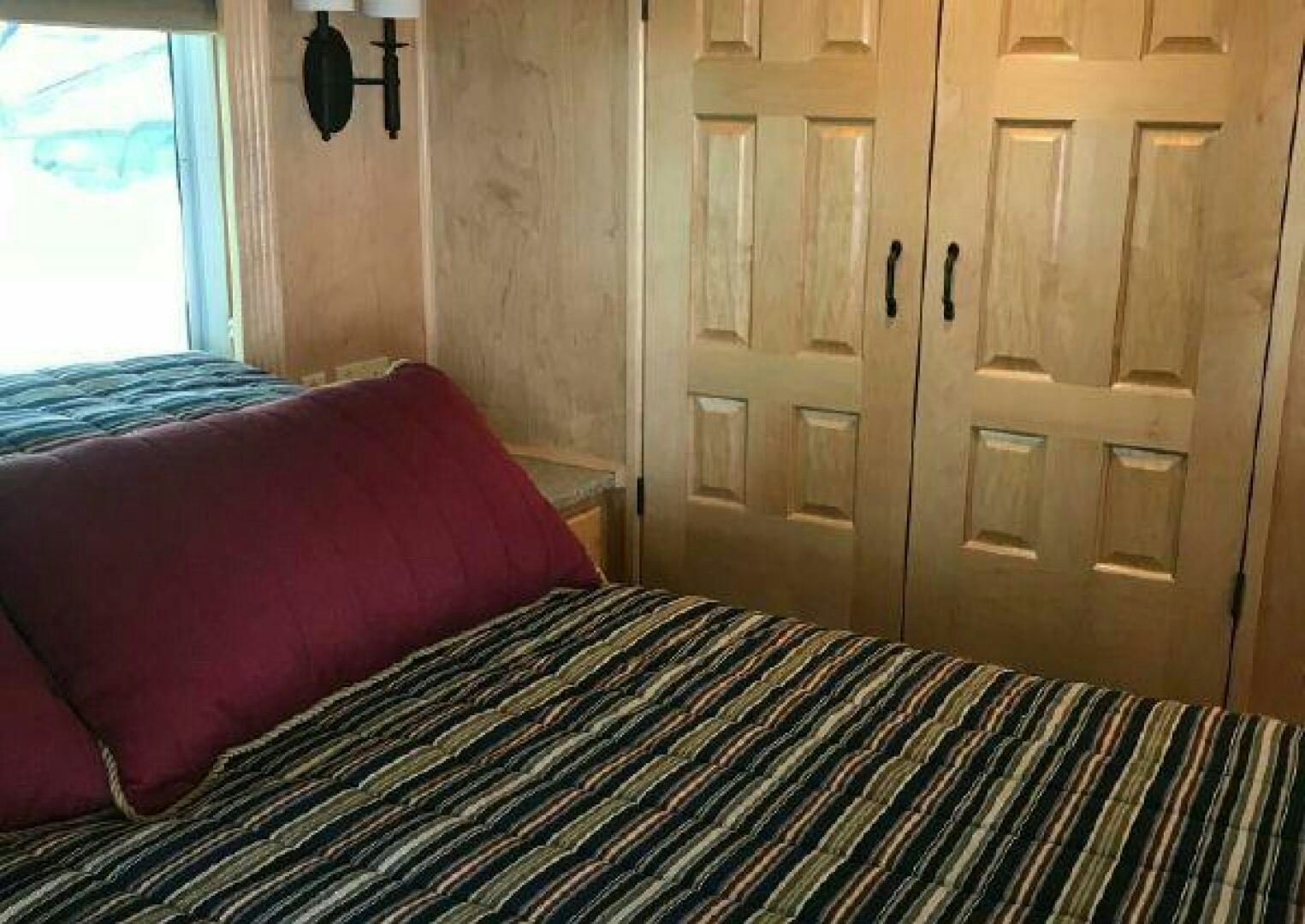 a bed with a red pillow aboard ST. SOMEWHERE Yacht for Sale