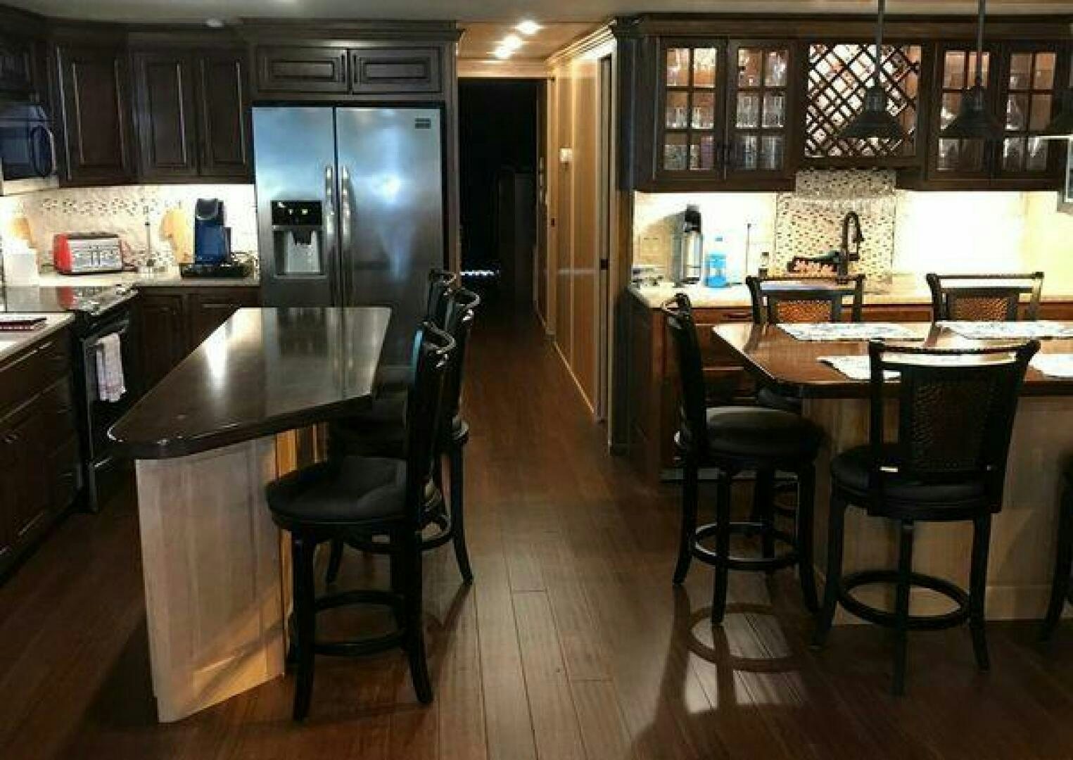 a kitchen with a bar stools and a table aboard ST. SOMEWHERE Yacht for Sale
