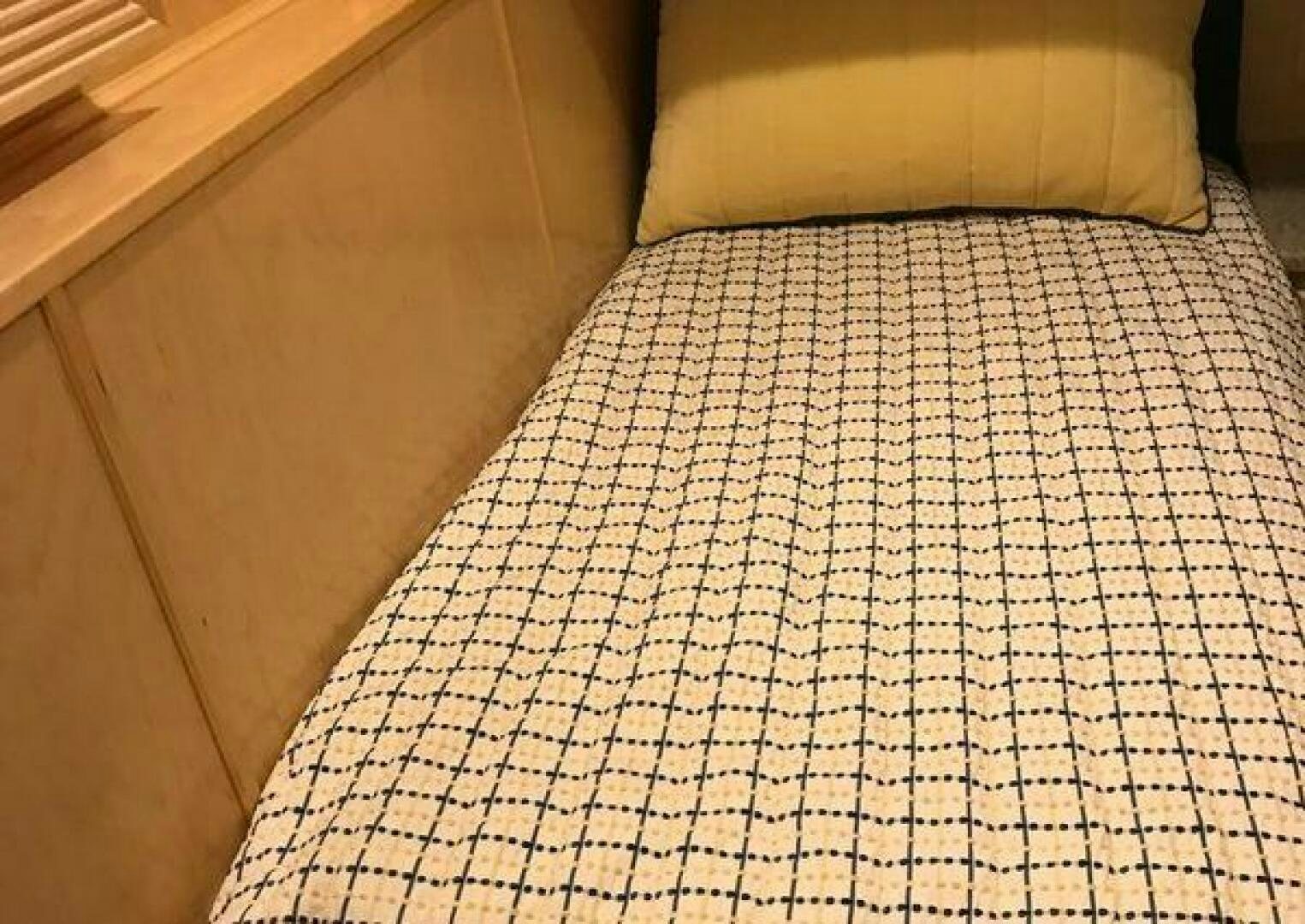 a bed with a white and black comforter aboard ST. SOMEWHERE Yacht for Sale