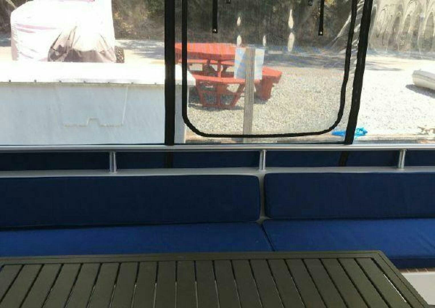 a window with a bench and a chair outside aboard ST. SOMEWHERE Yacht for Sale