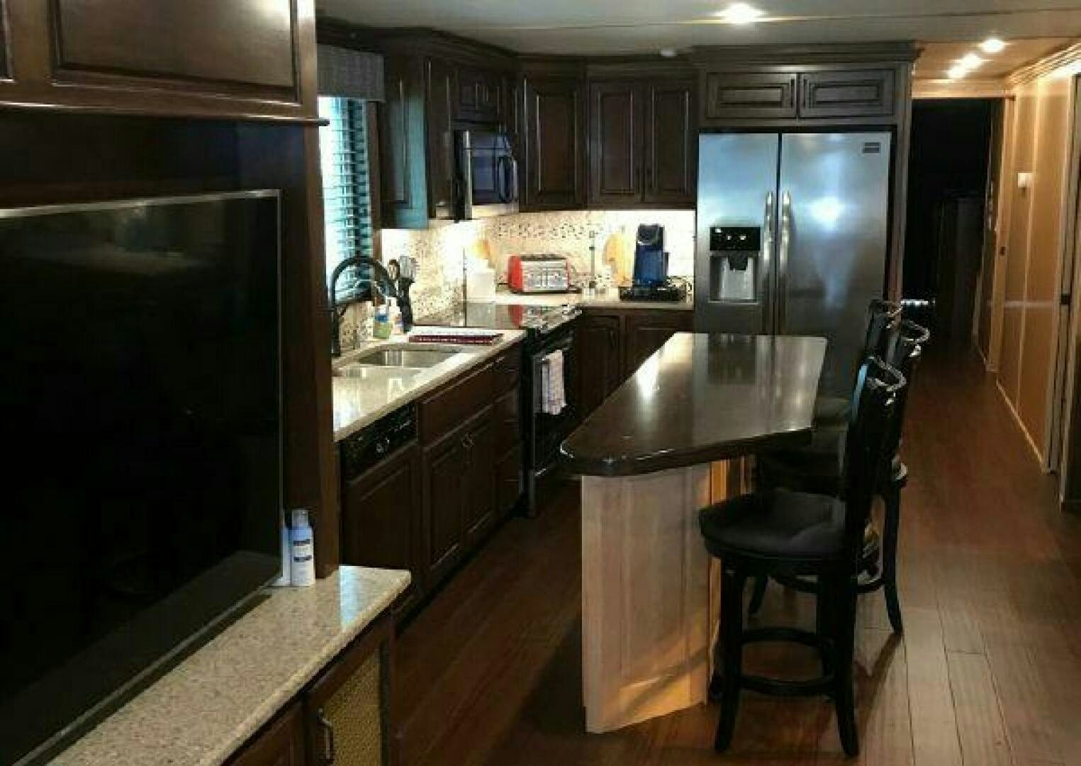 a kitchen with a bar stool and a bar stool aboard ST. SOMEWHERE Yacht for Sale