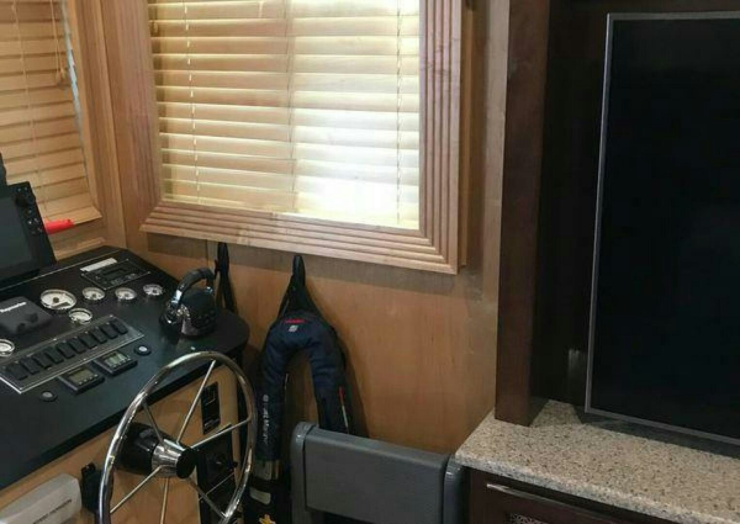 a room with a television and a guitar aboard ST. SOMEWHERE Yacht for Sale