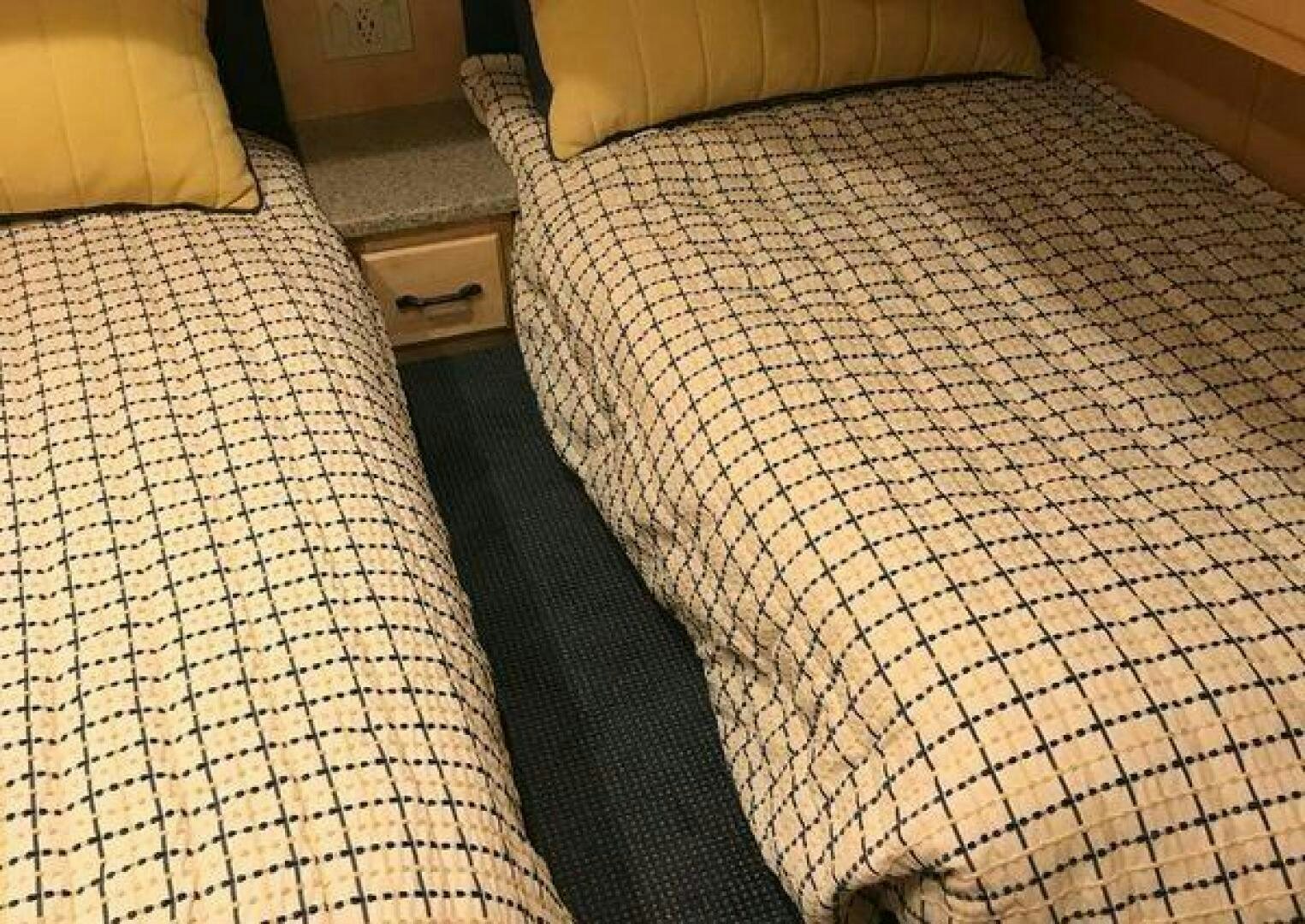 a pair of beds with a white comforter and a wooden headboard aboard ST. SOMEWHERE Yacht for Sale