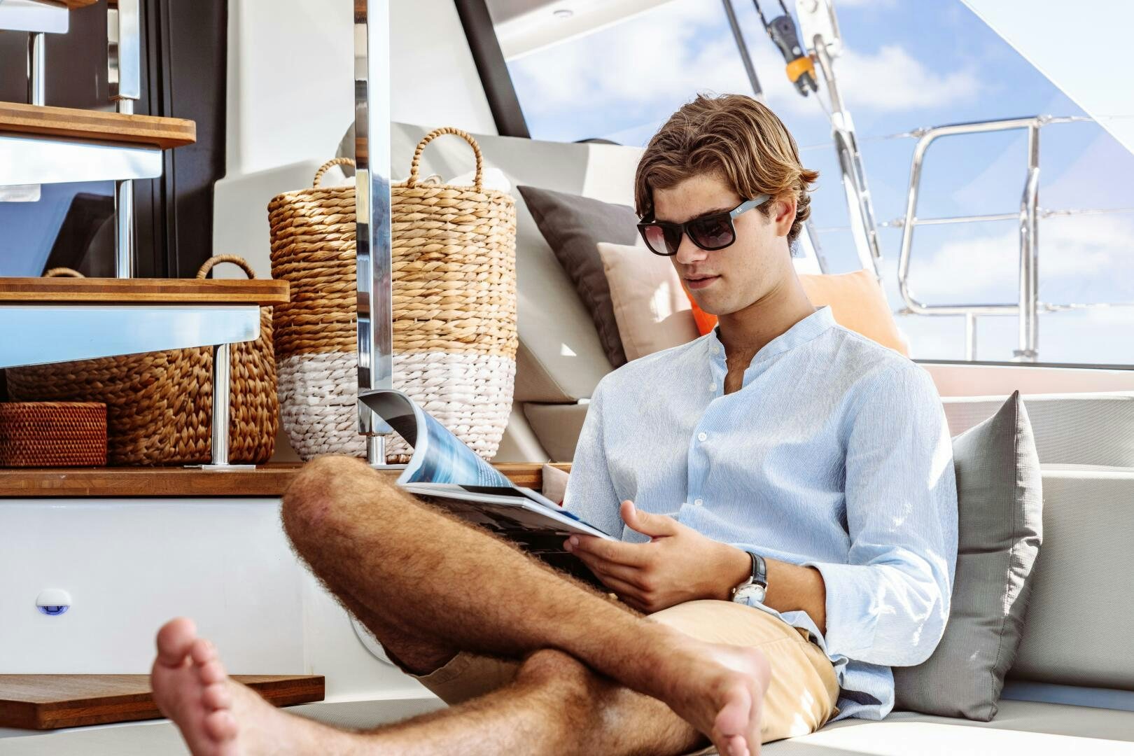 a person sitting on a couch reading a book aboard OCEANUS Yacht for Sale