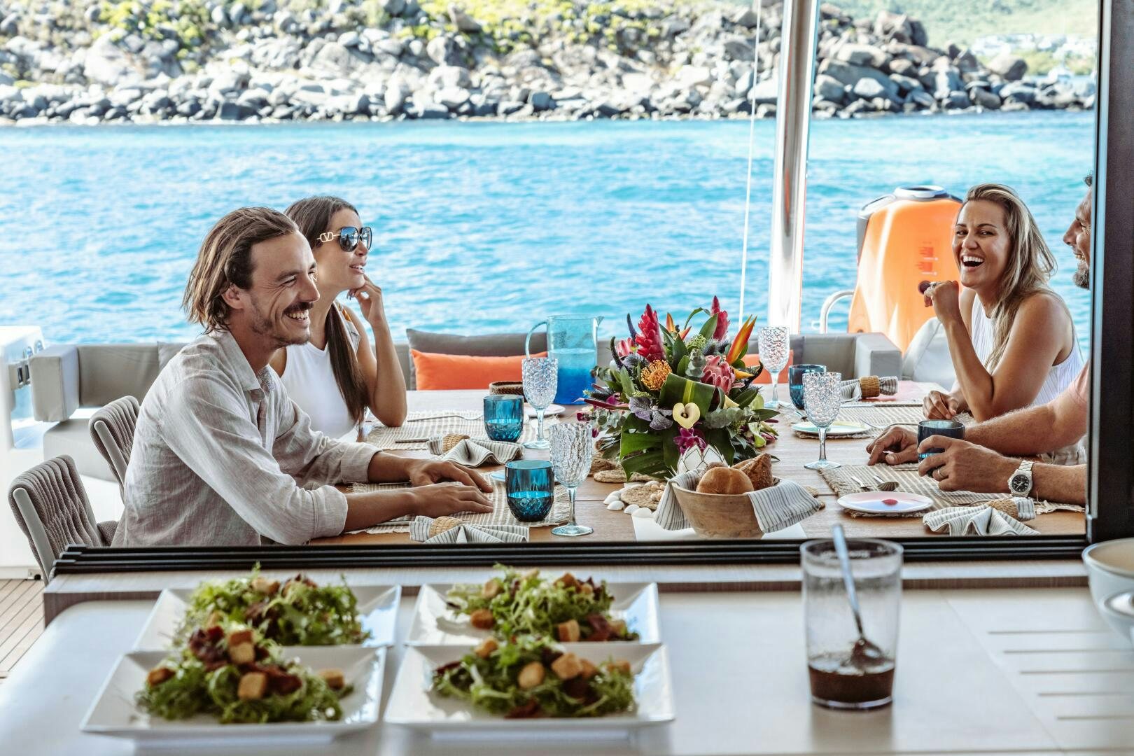 a group of people sitting at a table with food on it aboard OCEANUS Yacht for Sale