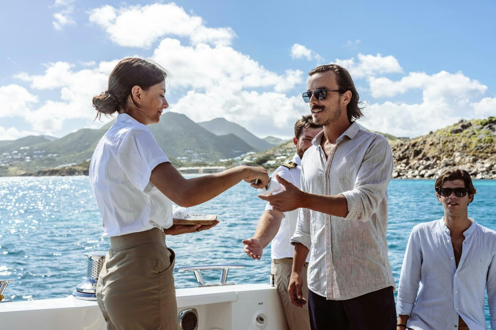 a group of people standing on a boat and looking at a person holding a fish aboard OCEANUS Yacht for Sale