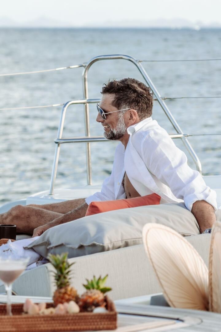 a man sitting on a boat aboard OCEANUS Yacht for Sale
