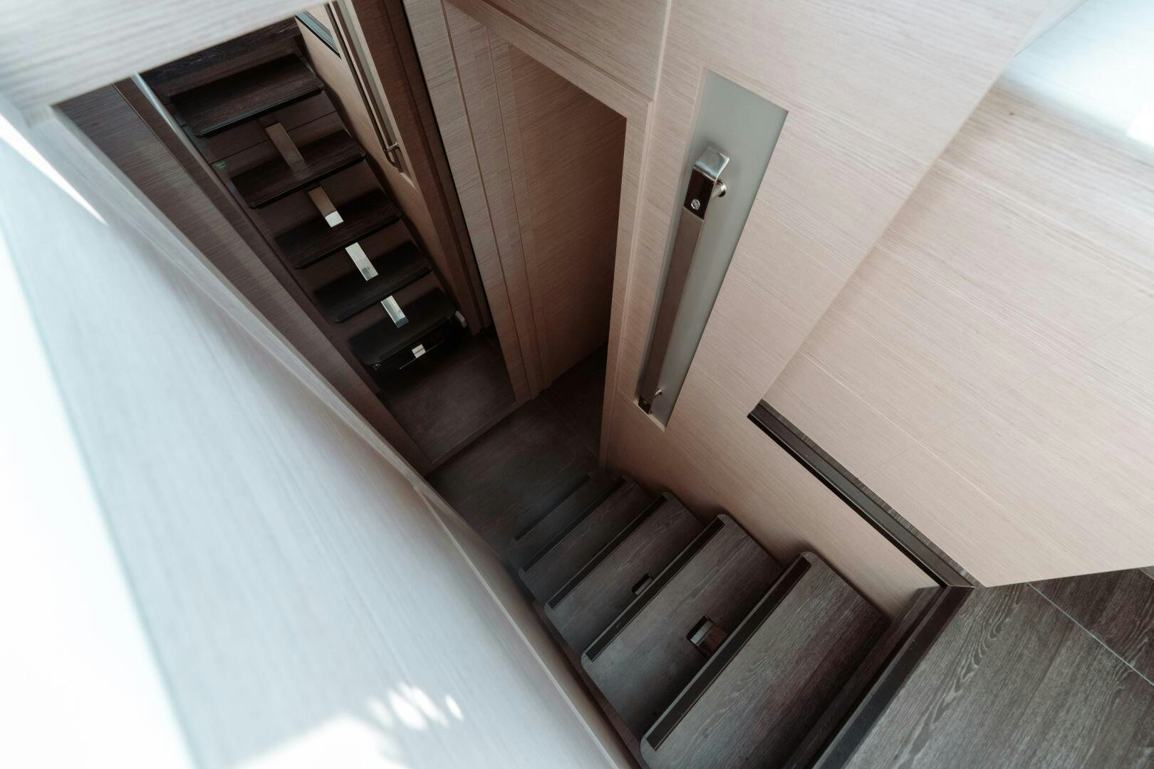 a wooden staircase with a glass door aboard OCEANUS Yacht for Sale