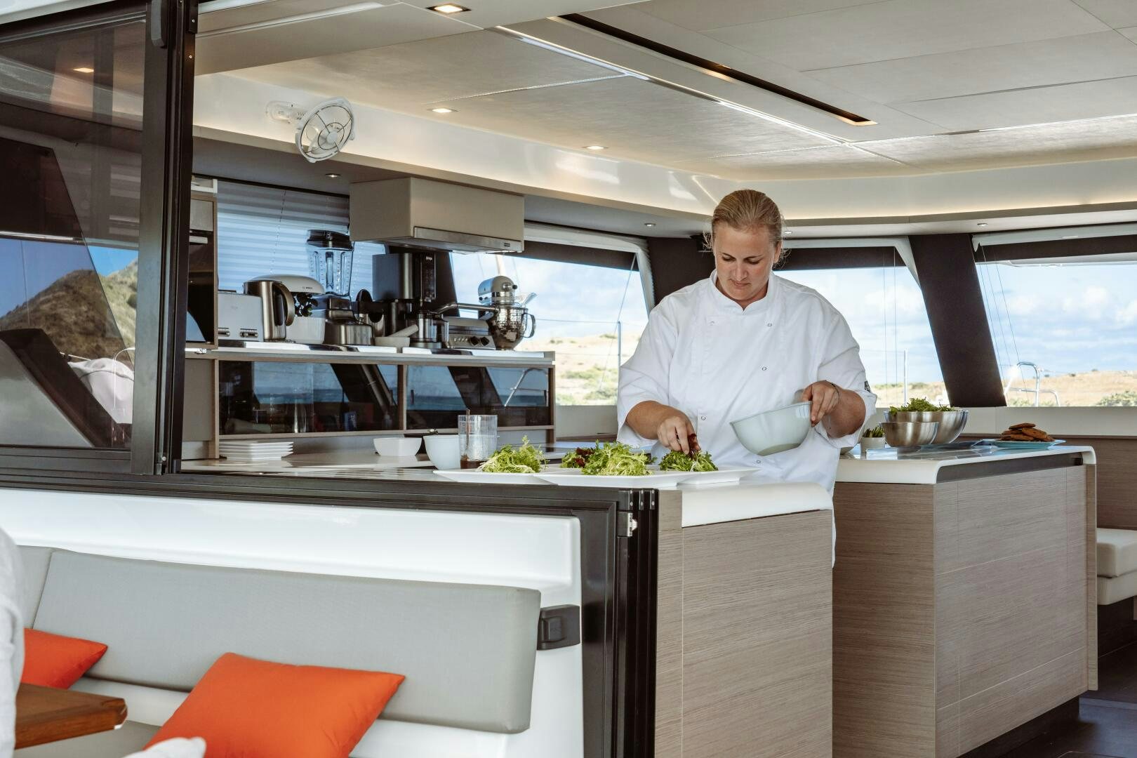a person in a kitchen preparing food aboard OCEANUS Yacht for Sale