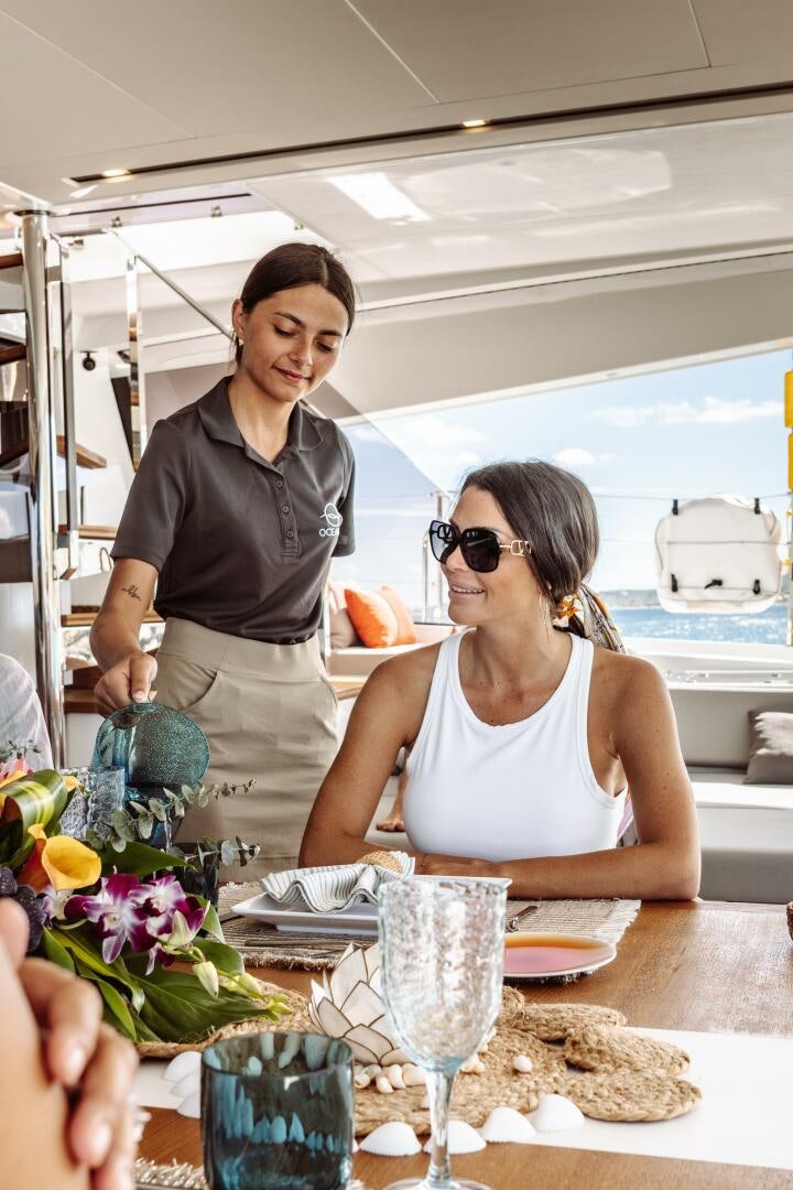 a man and woman at a table aboard OCEANUS Yacht for Sale