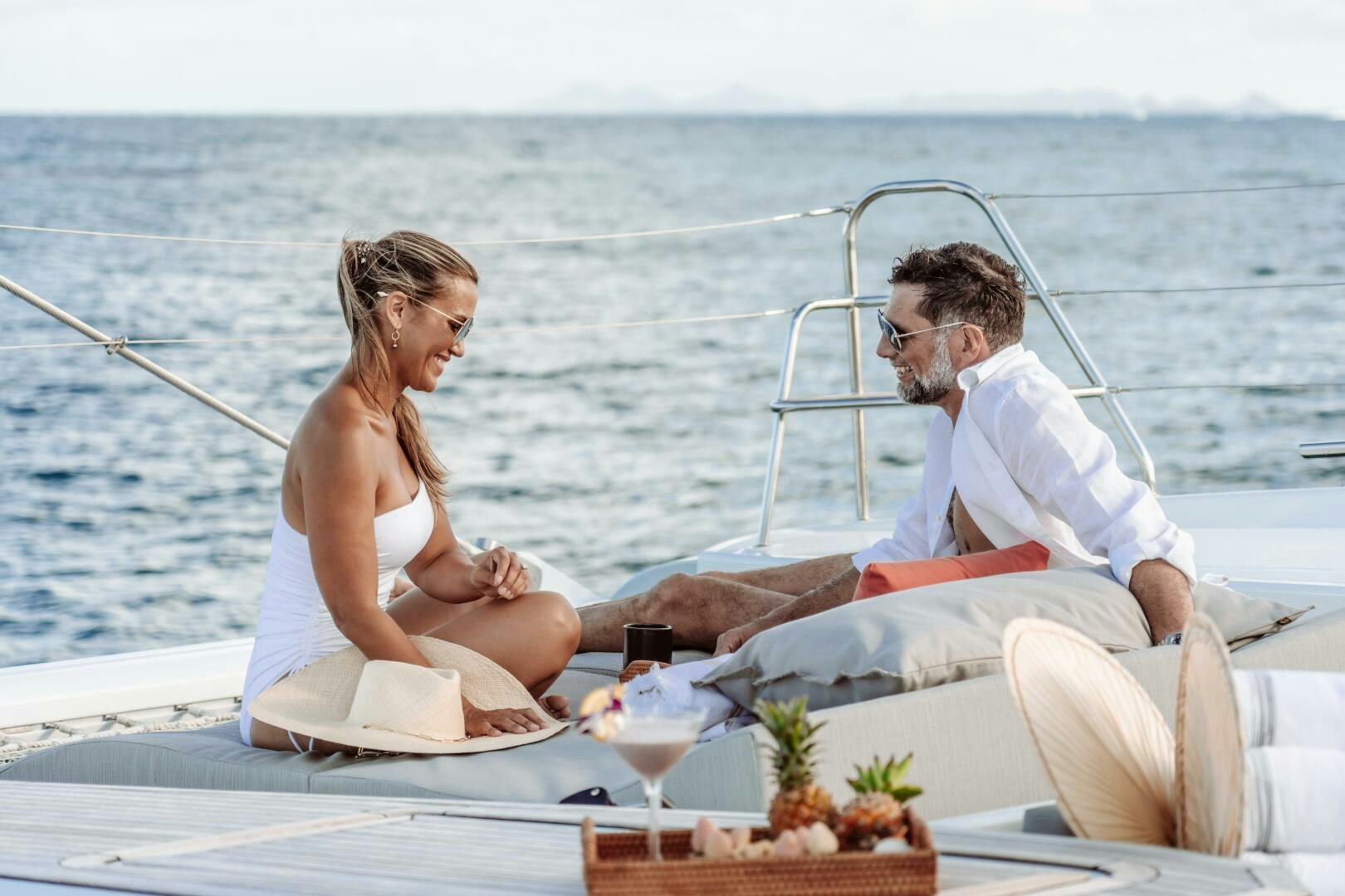 a man and woman sitting on a boat with a woman holding a drink aboard OCEANUS Yacht for Sale