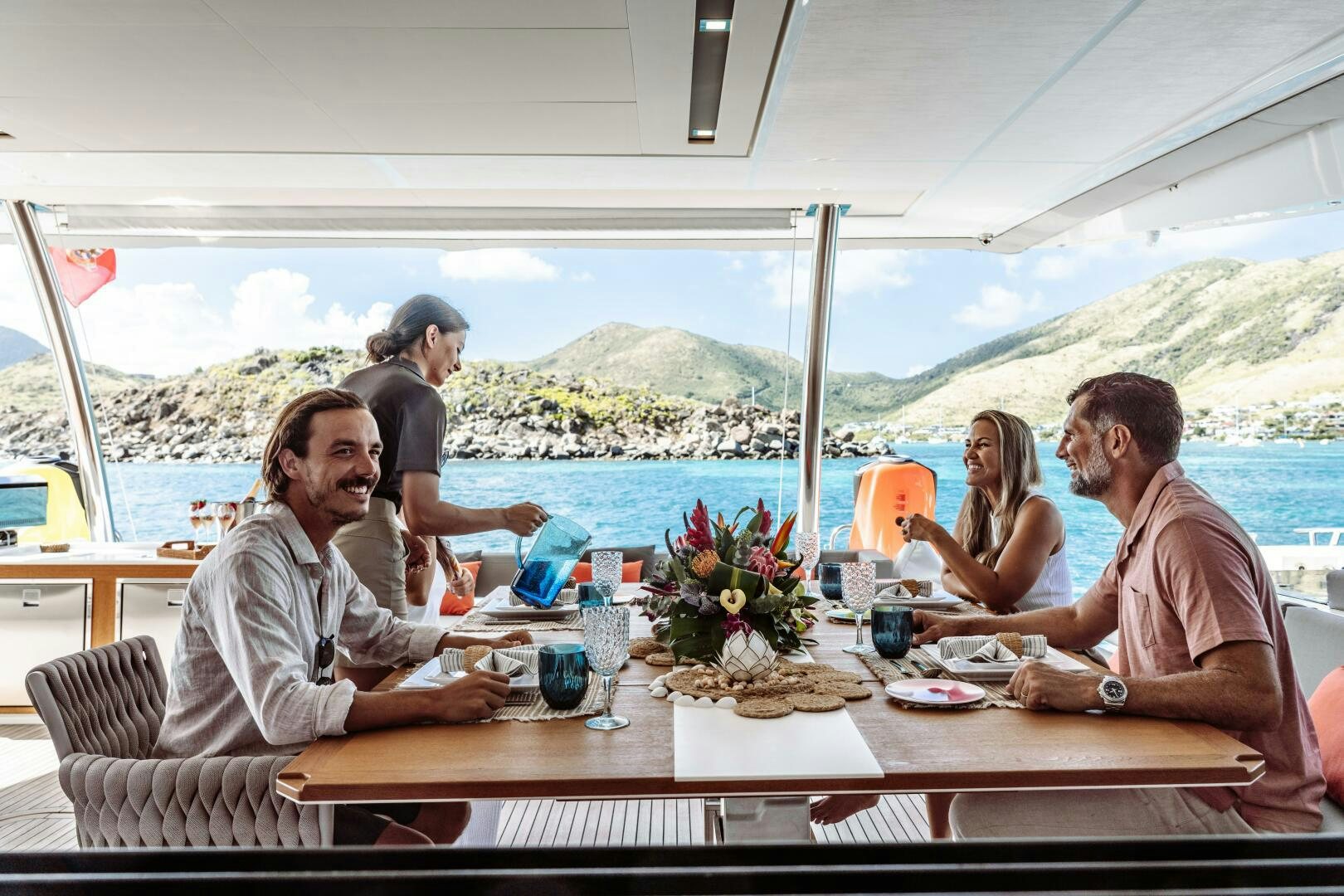 a group of people sitting around a table outside aboard OCEANUS Yacht for Sale