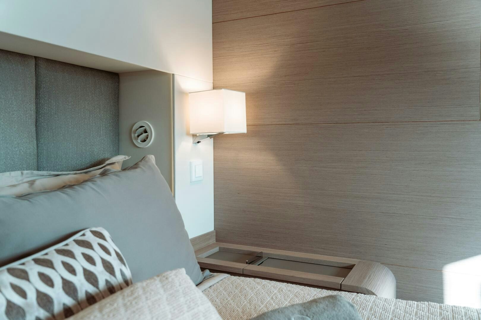 a bed with a wooden headboard aboard OCEANUS Yacht for Sale