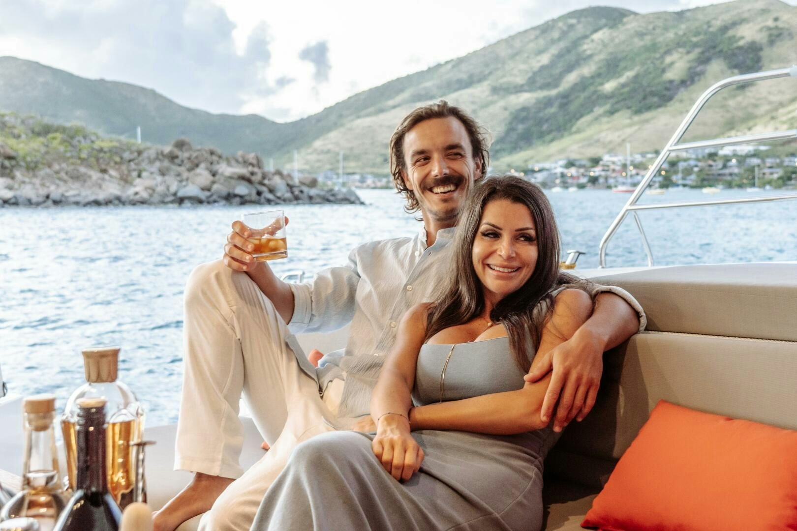 a man and woman sitting on a boat with a woman holding a sandwich aboard OCEANUS Yacht for Sale