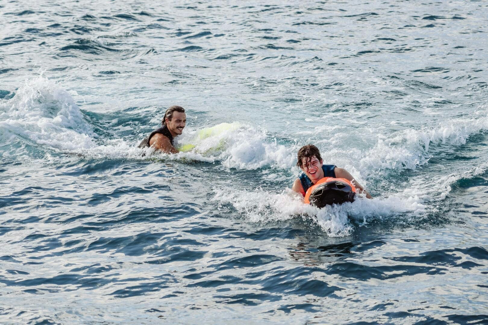 a group of people surfing aboard OCEANUS Yacht for Sale