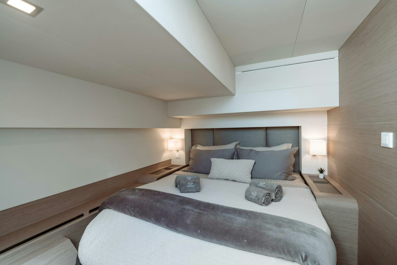 a bed with a white bed spread aboard OCEANUS Yacht for Sale