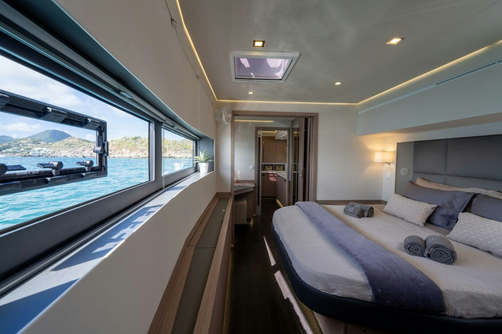 a boat with a bed and a large window aboard OCEANUS Yacht for Sale