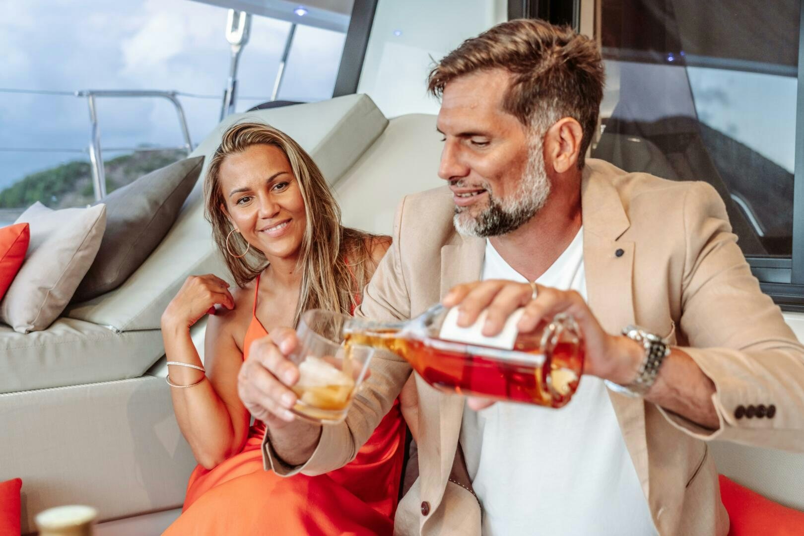 a man and woman holding drinks aboard OCEANUS Yacht for Sale