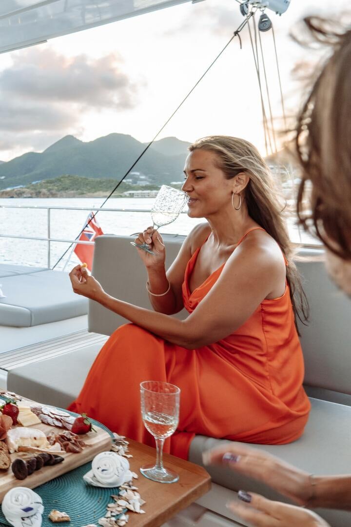 a person sitting at a table with a plate of food and a glass of wine aboard OCEANUS Yacht for Sale