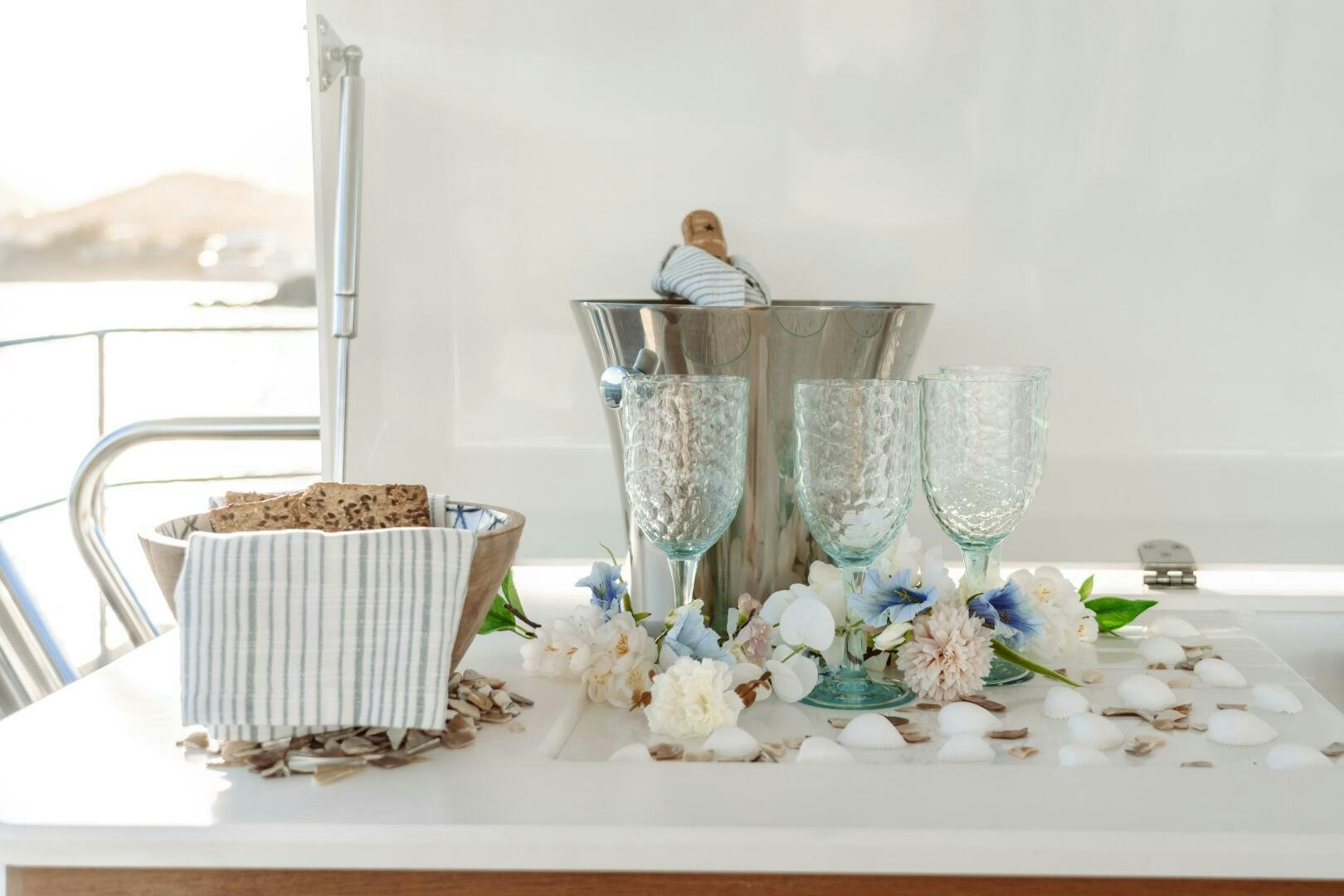 a table with a variety of glasses and a person sitting at the table aboard OCEANUS Yacht for Sale