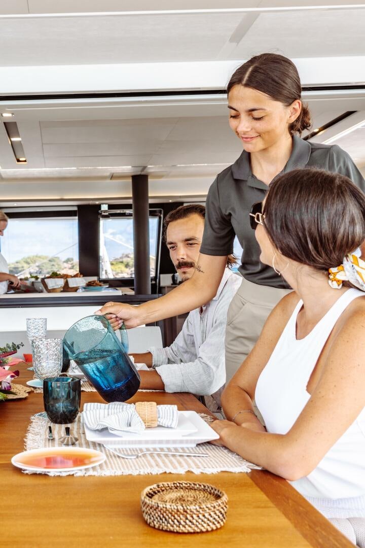 a family sits at a table aboard OCEANUS Yacht for Sale
