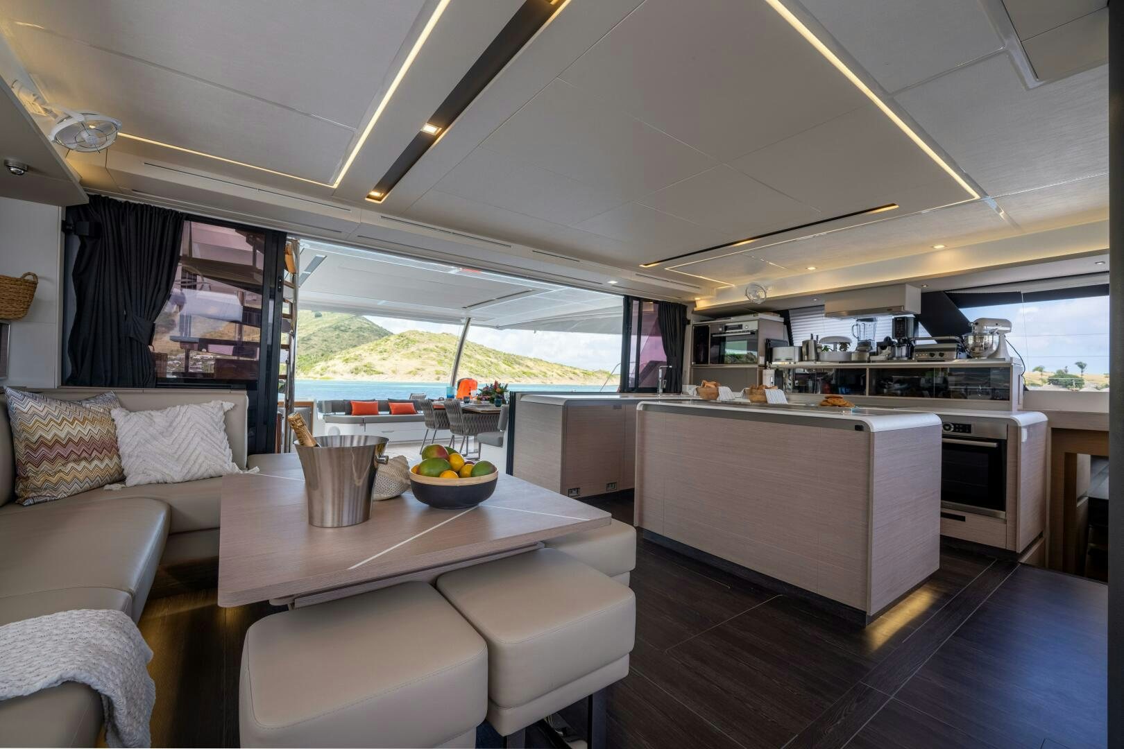 a kitchen with a table and couches aboard OCEANUS Yacht for Sale