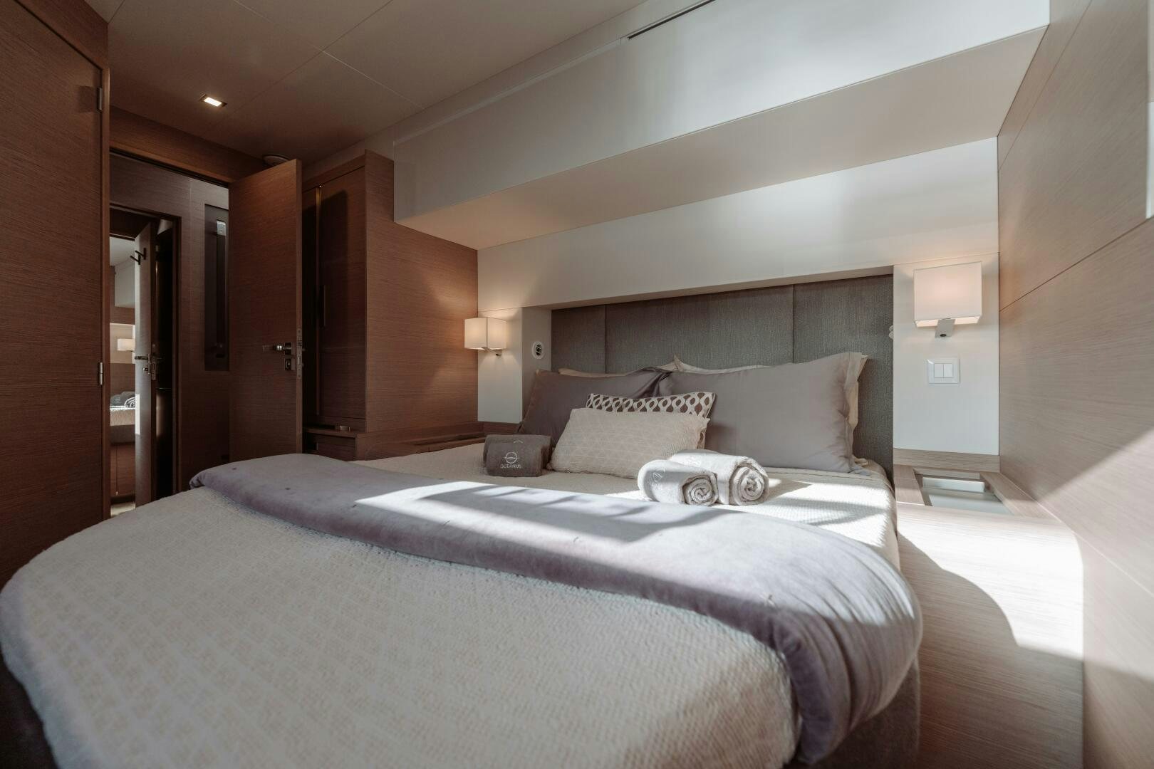 a bed with a white comforter aboard OCEANUS Yacht for Sale
