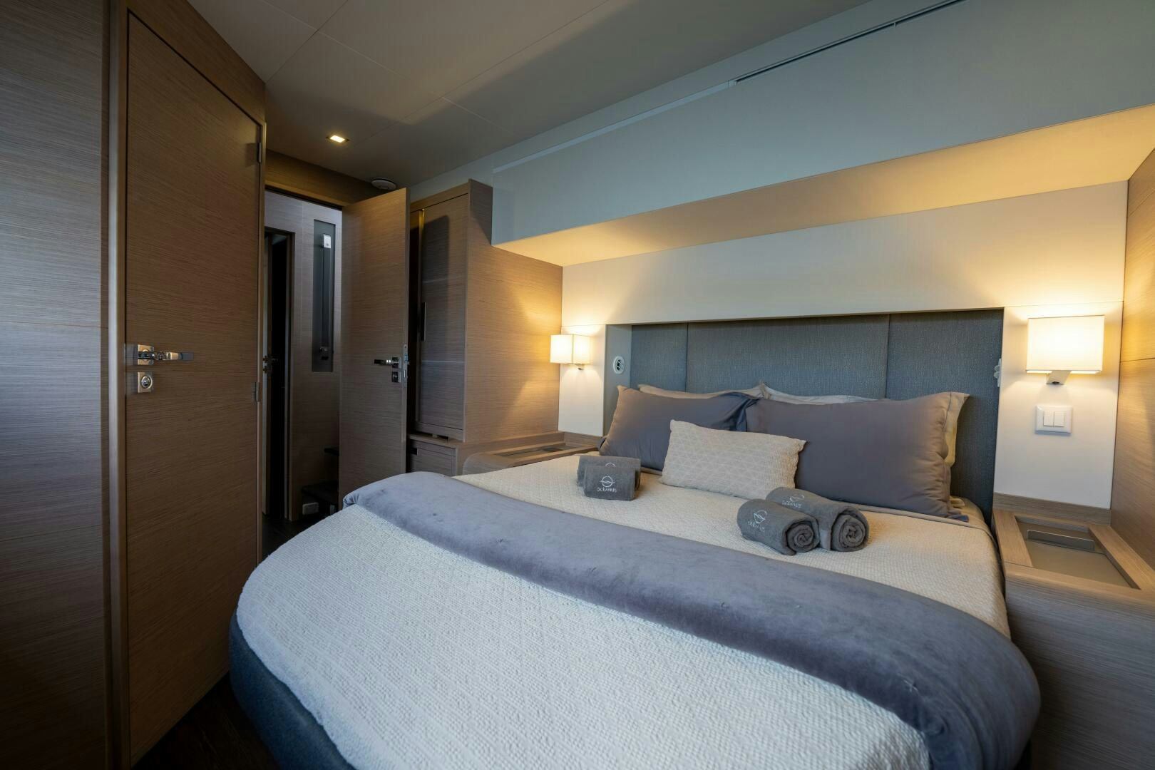 a bed with a blue comforter aboard OCEANUS Yacht for Sale