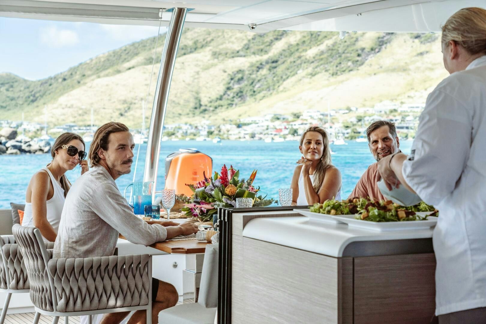 a group of people sitting at a table with food on it aboard OCEANUS Yacht for Sale