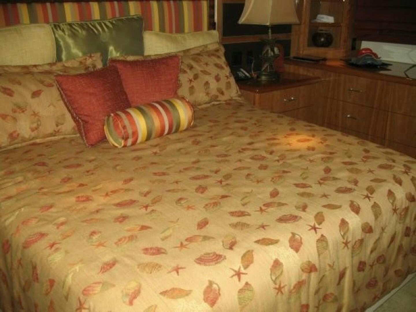 a bed with colorful pillows aboard LIVNWEL Yacht for Sale