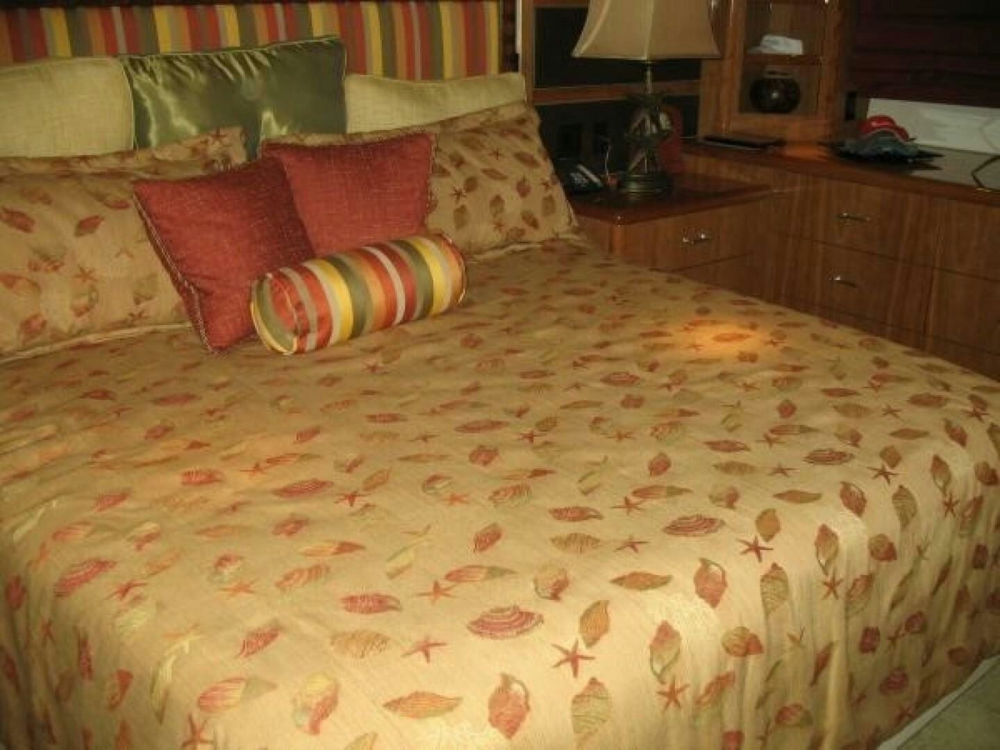 a bed with colorful pillows aboard LIVNWEL Yacht for Sale