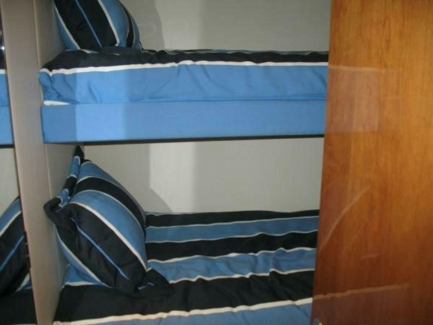 a bed with blue and white striped sheets aboard LIVNWEL Yacht for Sale