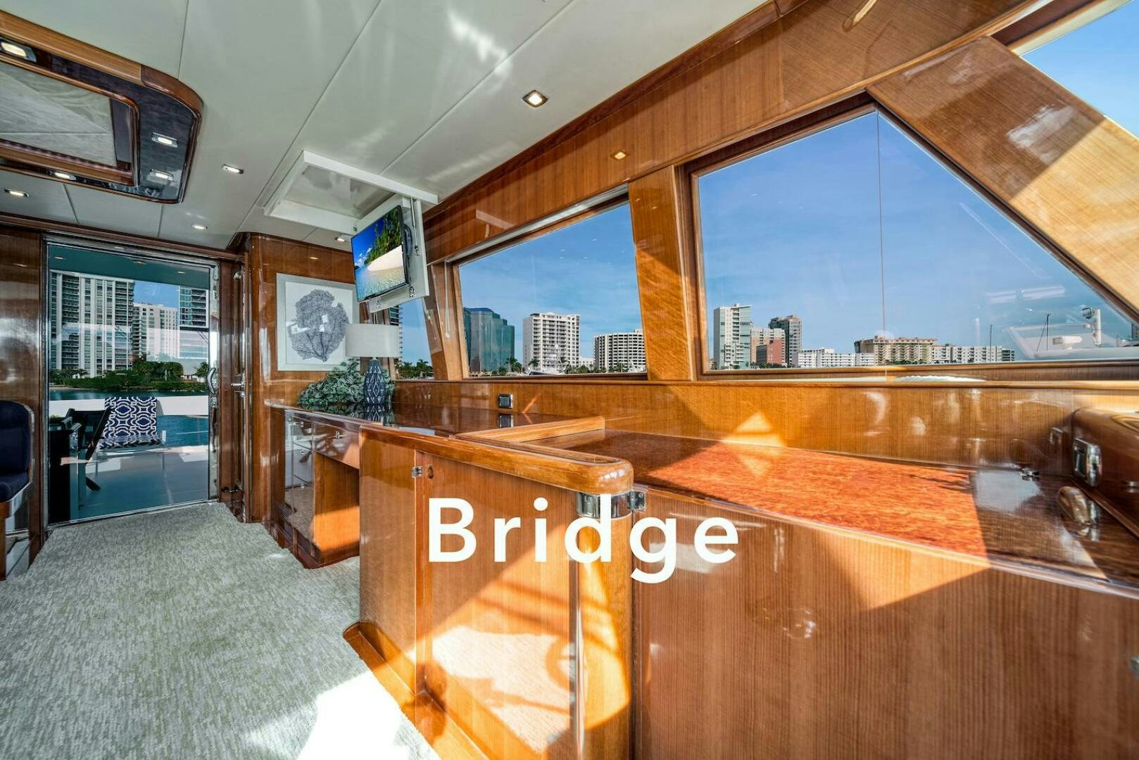 a room with a large window and wood furniture aboard ESCAPE Yacht for Sale
