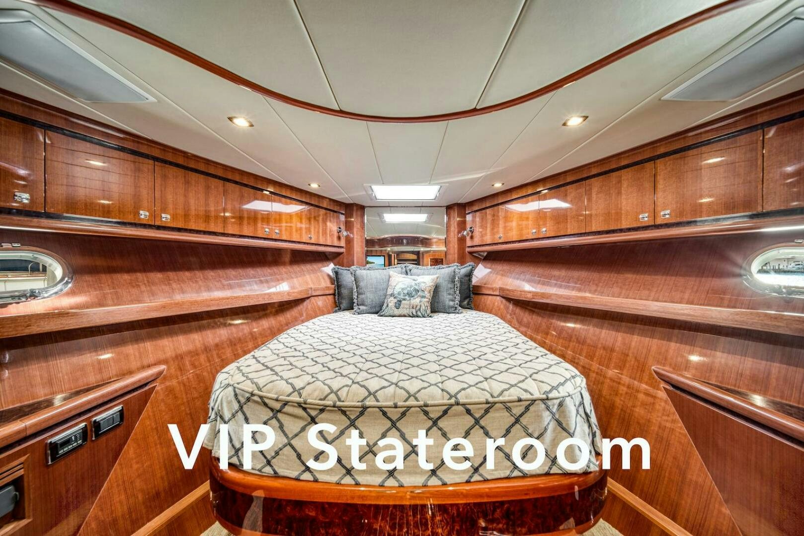 a room with a bed and wooden cabinets aboard ESCAPE Yacht for Sale