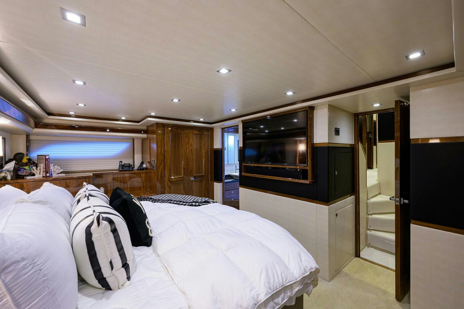 a room with a bed and a television aboard 80' VIKING Yacht for Sale