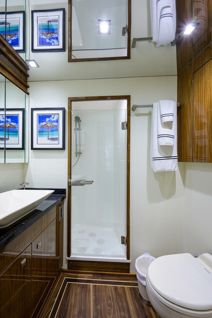 a bathroom with a shower and toilet aboard 80' VIKING Yacht for Sale