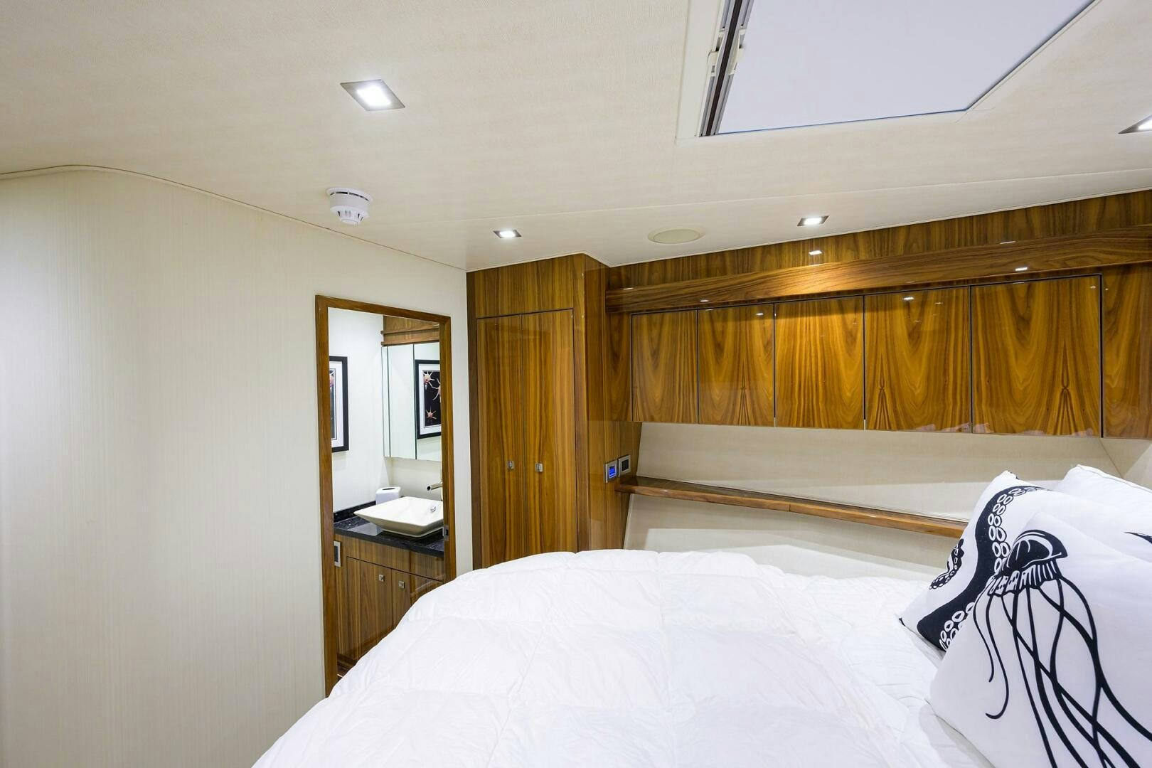 a bedroom with a bed and a mirror aboard 80' VIKING Yacht for Sale